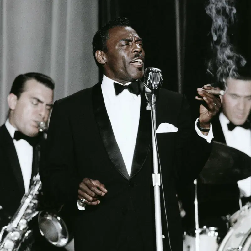 Vintage jazz band performance with a singer holding a microphone and cigar