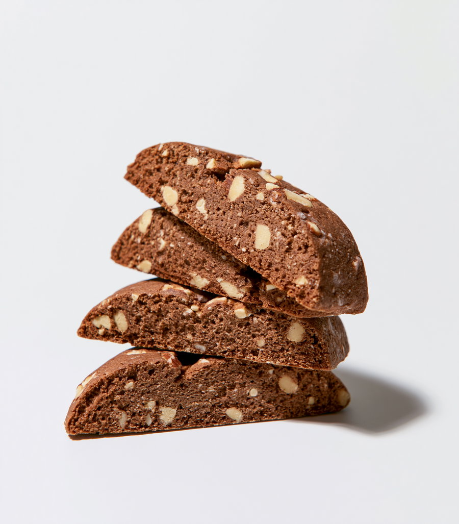Stacked almond chocolate biscotti on a white surface