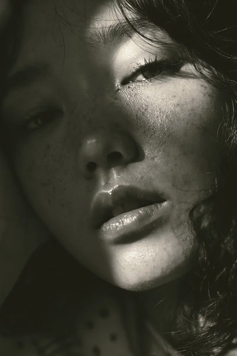 Moody close-up artistic portrait of a woman's face with light and shadow play