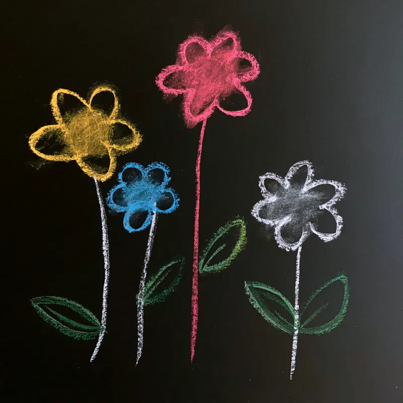 Colorful chalk drawing of whimsical flowers on a black background