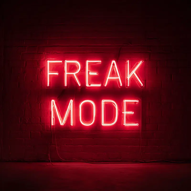 Red Neon Sign Saying Freak Mode on Dark Brick Wall for Bold Interior Statement