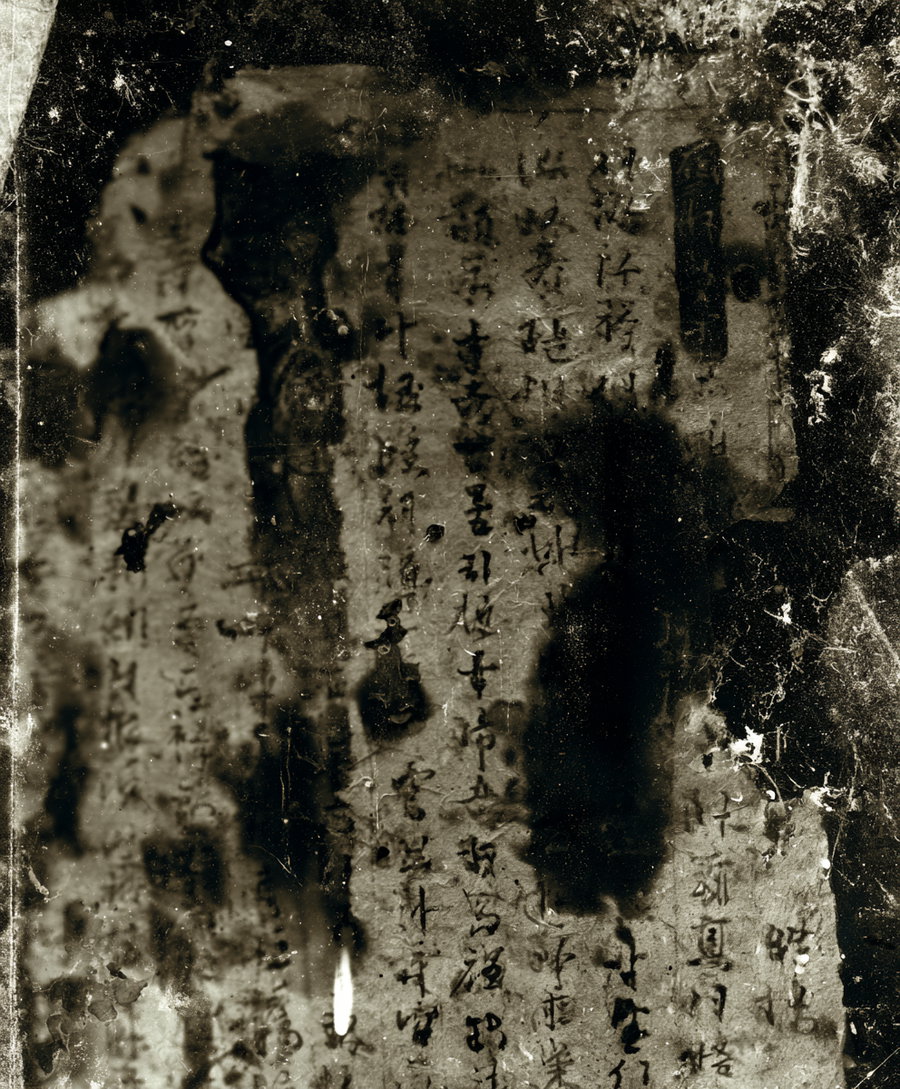 Aged, stained paper featuring faded Asian calligraphy and markings in black ink