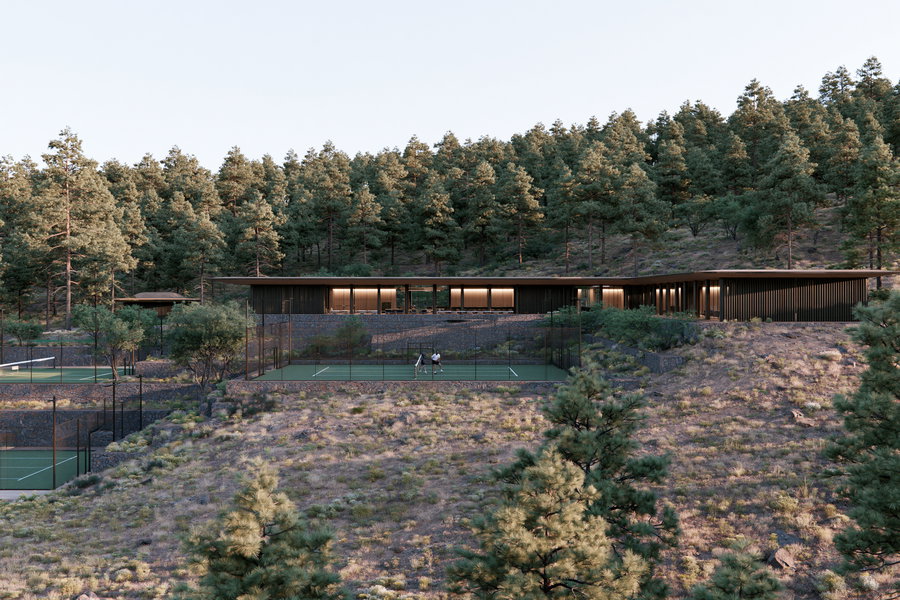 A sleek, modern house situated on a hillside with two tennis courts in front, surrounded by dense pine trees and natural vegetation.