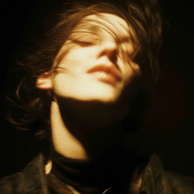Soft focused portrait of a person with hair flowing in warm light