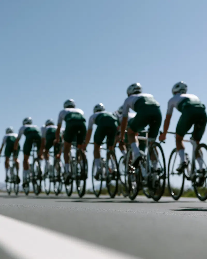 Dynamic wall art of a cycling team riding in formation on a clear day