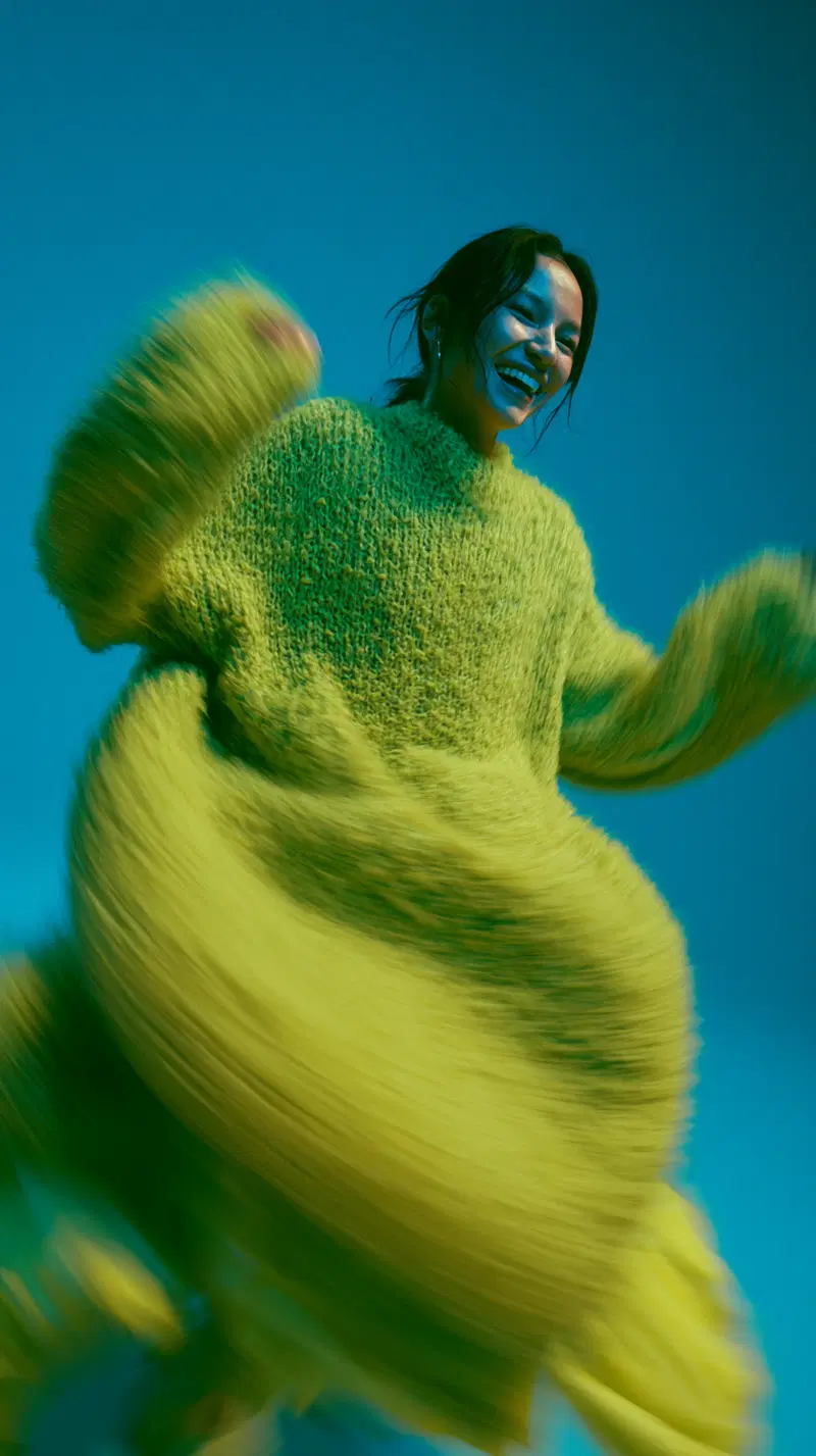 Vibrant portrait of a joyful woman in a bright yellow textured sweater