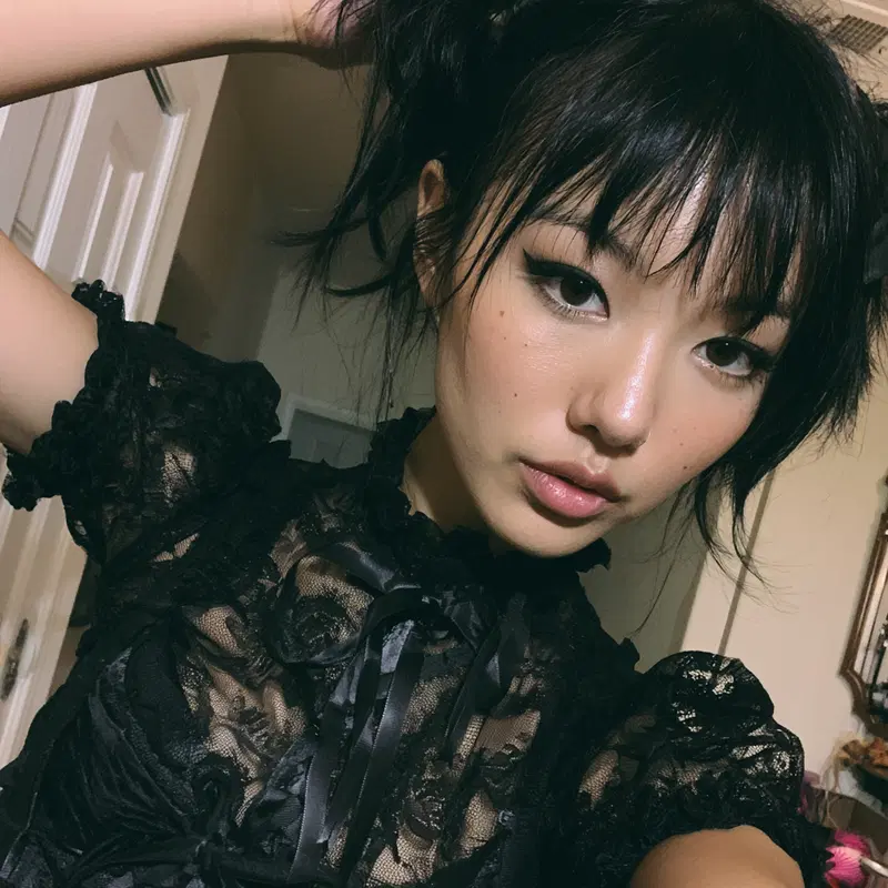 Close-up portrait of a woman in black lace vintage style top with dramatic eyeliner
