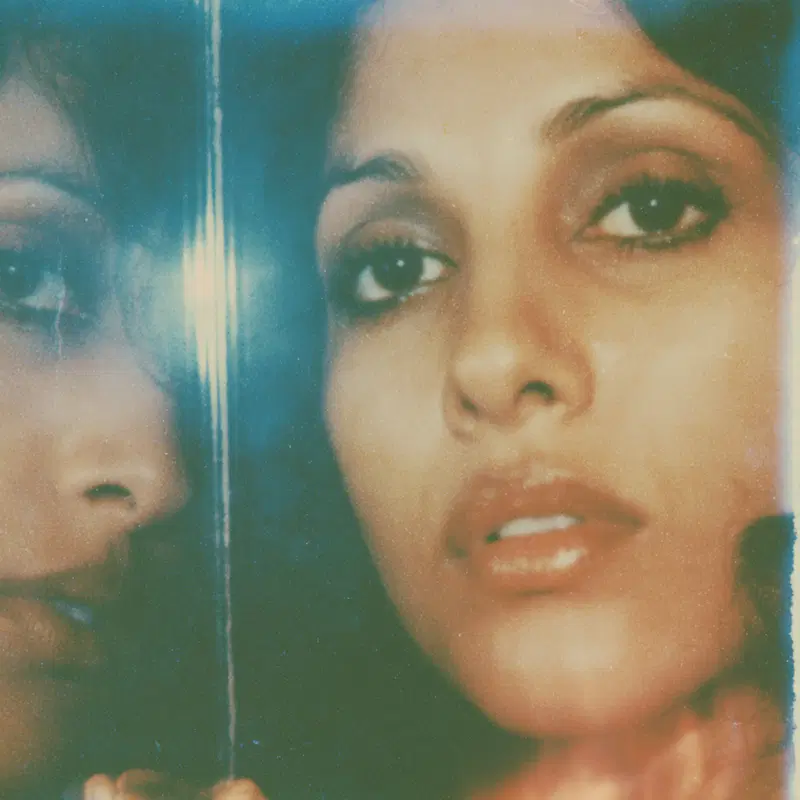 Close-up vintage-style portrait of a woman reflected in a mirror