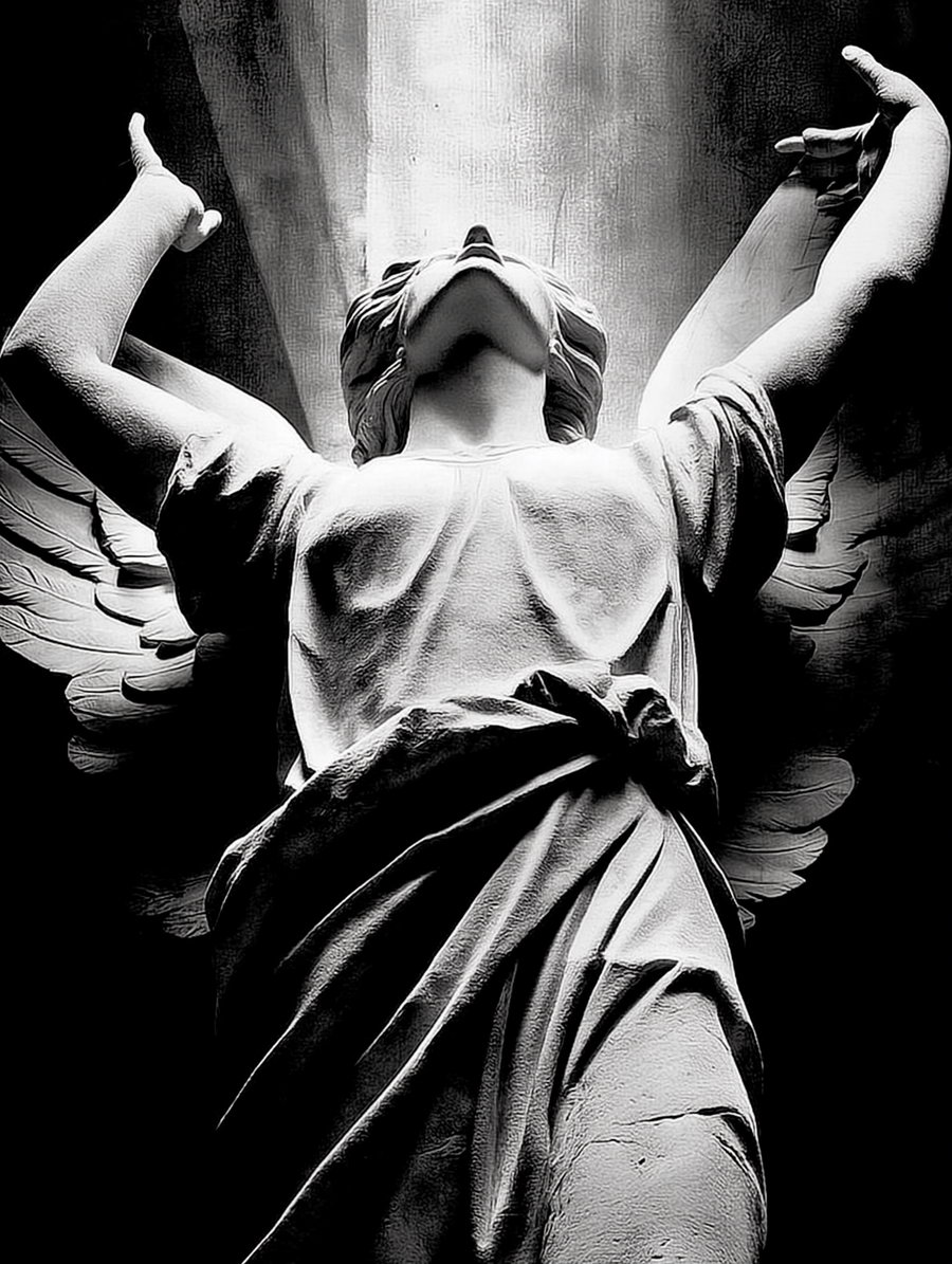 A black and white image showing an angel statue from a low angle with wings spread and head tilted upward under dramatic lighting