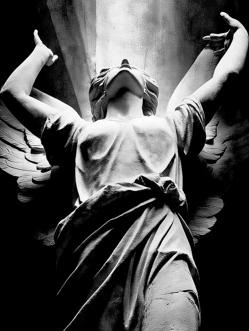 Black and white artistic photograph of an angel statue illuminated dramatically