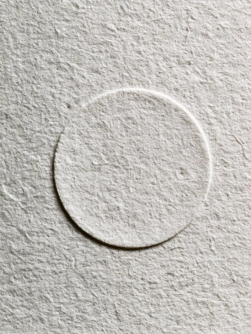 Minimalist textured white paper with circular embossed design