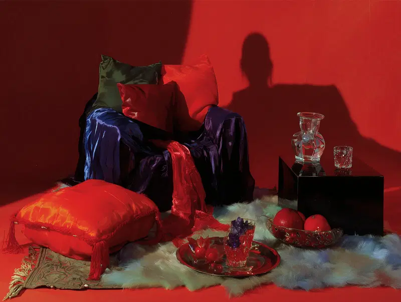 Still Life Composition Featuring Vibrant Textiles and Glassware on a Red Background