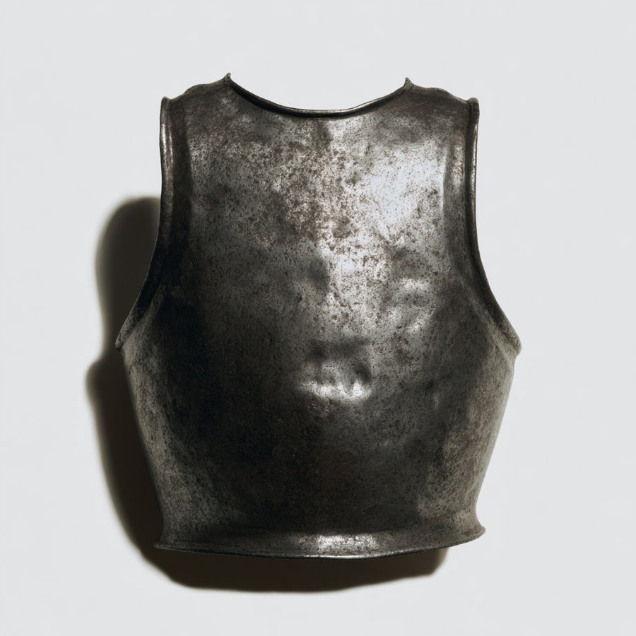 A medieval metal breastplate with a weathered and aged surface casting a shadow on a plain light background