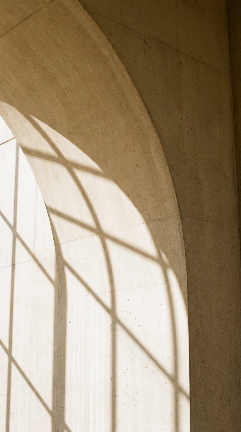 Shadow of a window with grid pattern on a curved beige concrete wall