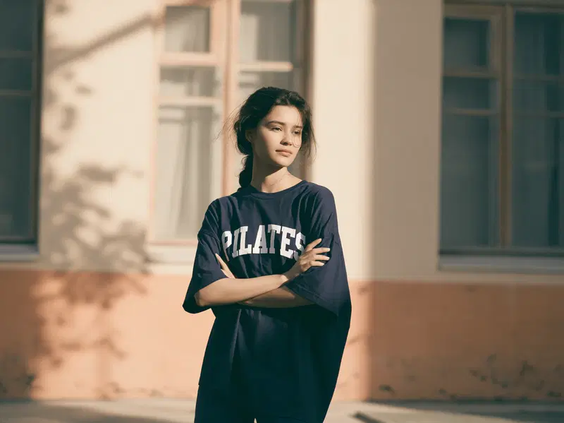 A Girl in a Navy Blue Oversized T-Shirt with PILATES Print