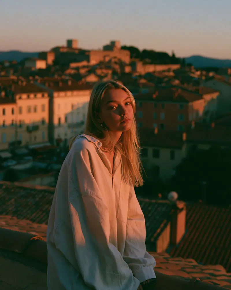 Young Woman on Rooftop Terrace Overlooking a European City at Dusk