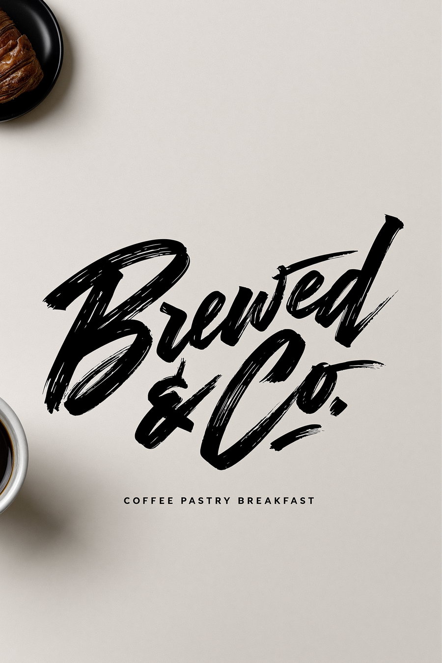 Bold brush script lettering of 'Brewed & Co.' in black on an off-white cream background, coffee cup and pastry visible in the corner, minimal layout.