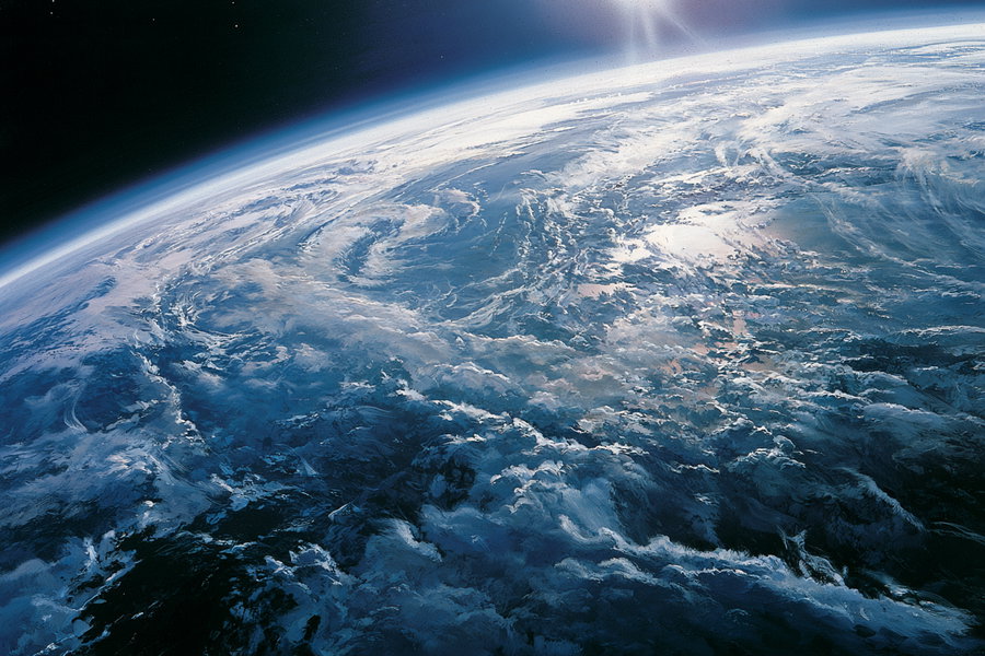 An aerial view of Earth from space, showcasing swirling clouds and blue oceans.