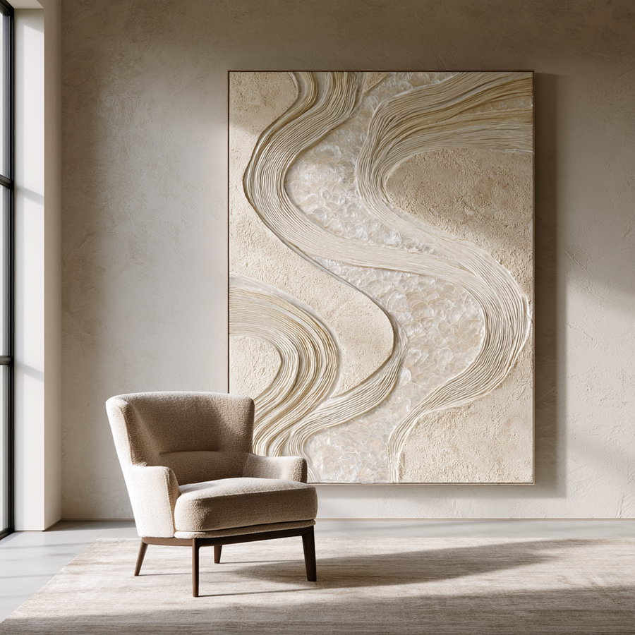 A large-scale textured wall art piece with flowing sculptural ribbons made from ivory rope and layered translucent capiz shells, set in a minimalist interior with soft natural lighting and a single beige chair.
