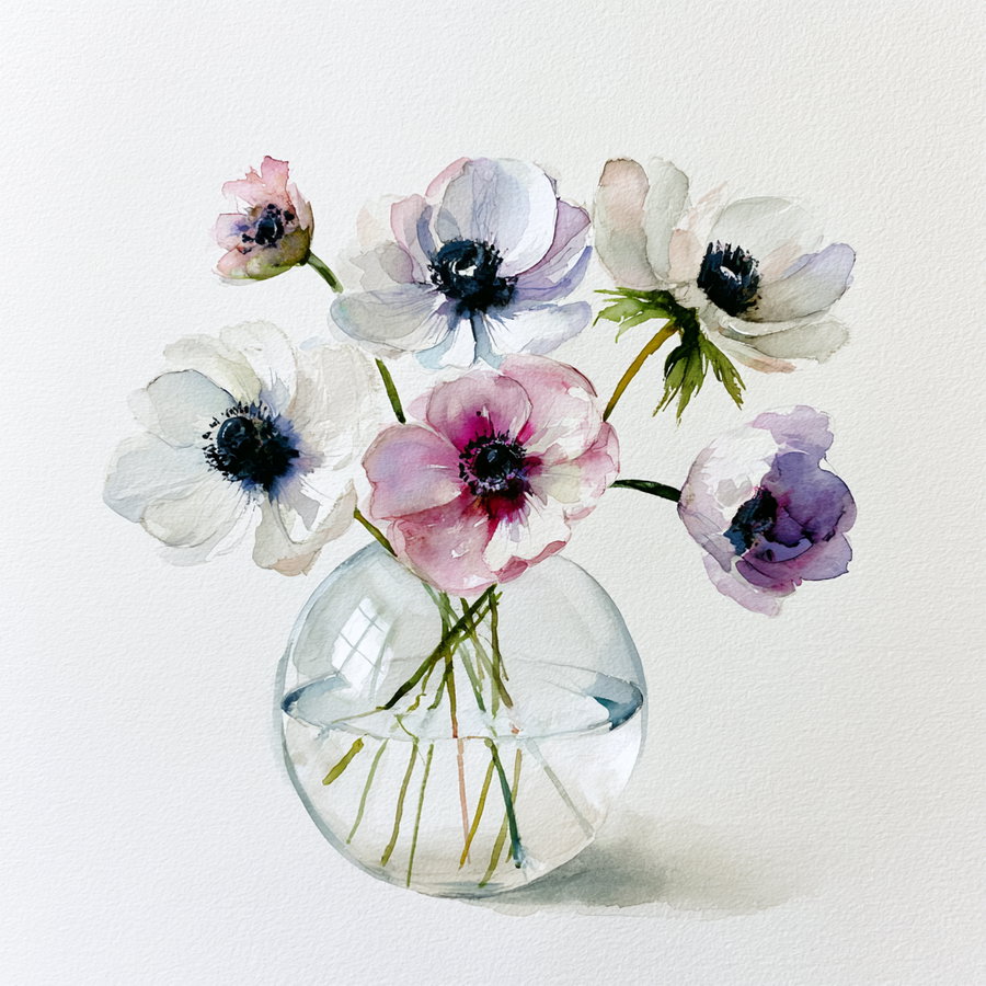 A round glass vase containing several Anemone flowers in shades of white and pink, set against a white background.