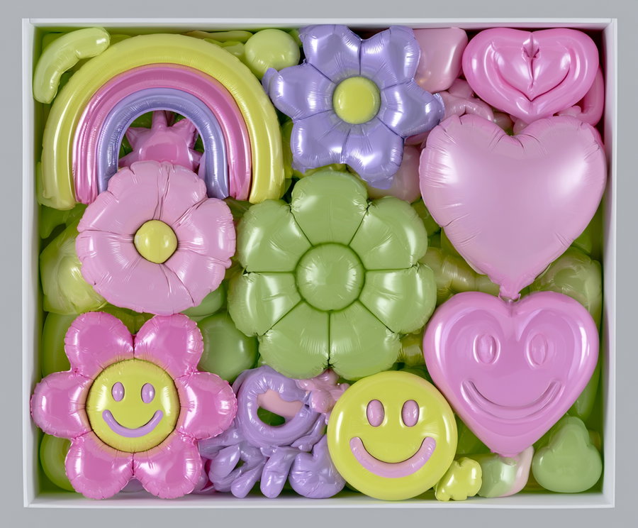 A collection of various inflated shapes including flowers, a rainbow, happy emojis, and heart shapes in pastel colors, all contained within a white box.